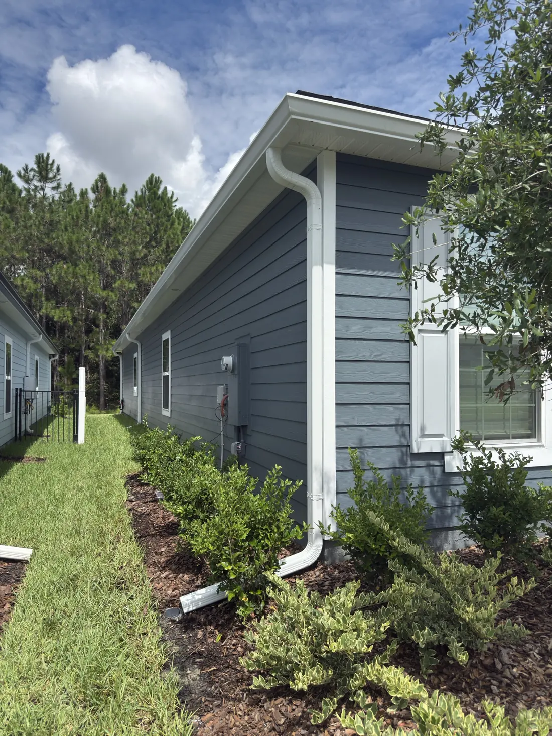 New construction home with freshly installed seamless white gutters over the garage